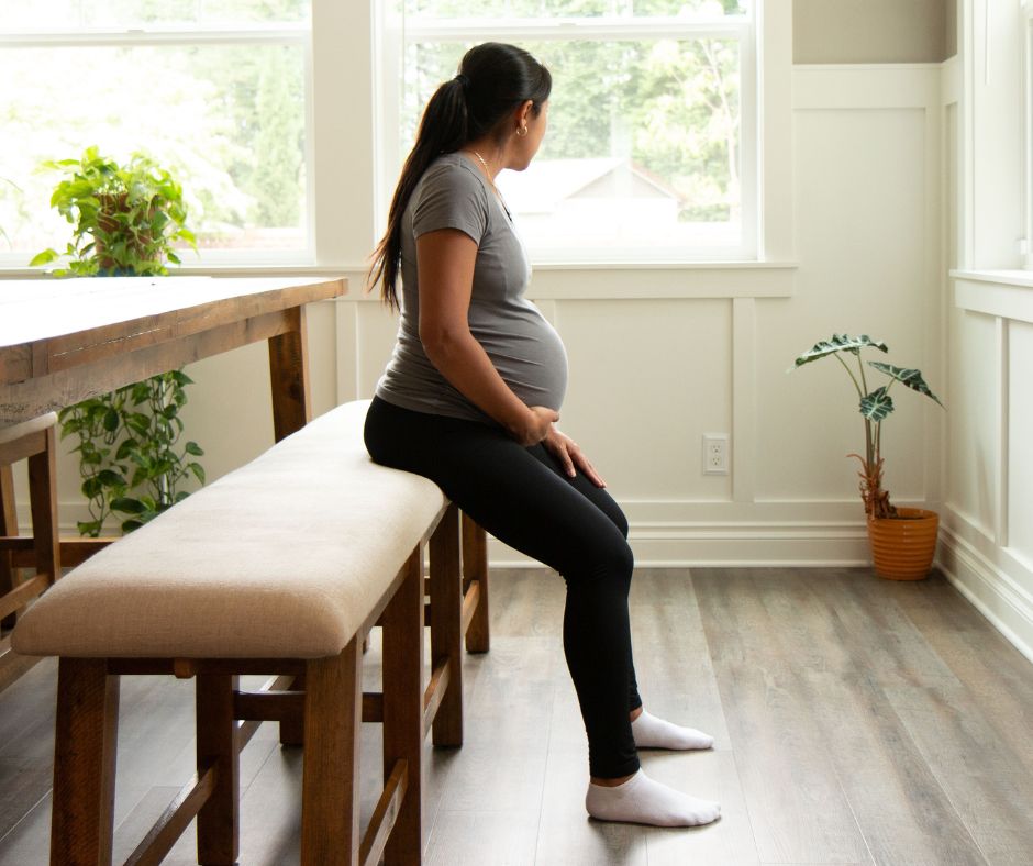 pregnant hispanic woman sitting on a bench