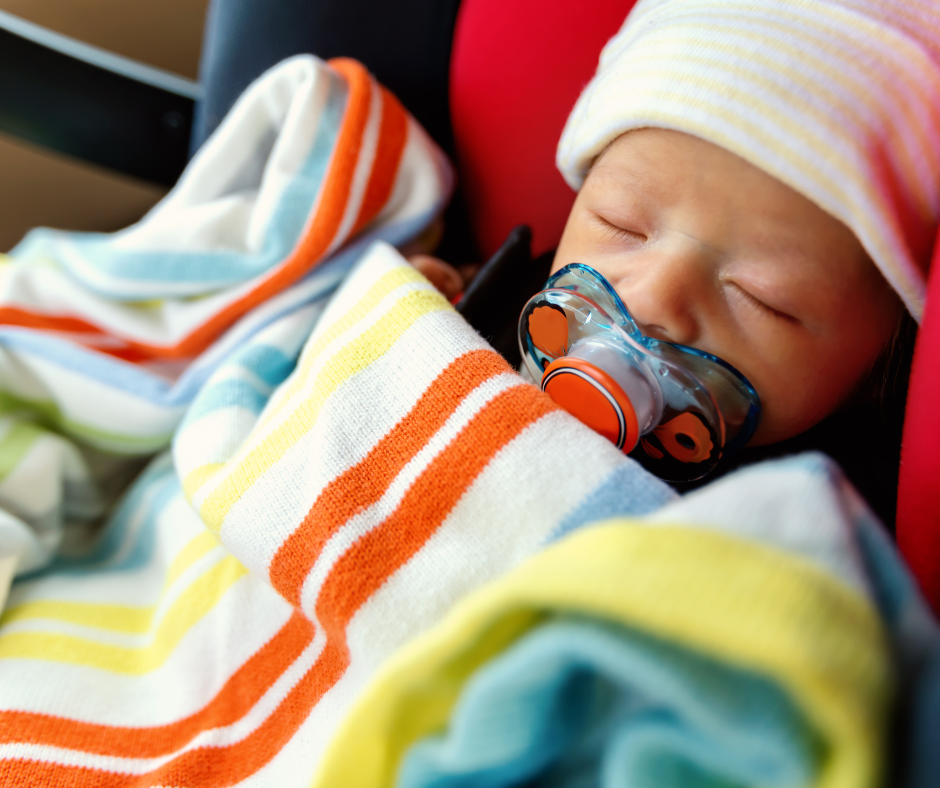 adopted newborn baby with pacifier in car seat