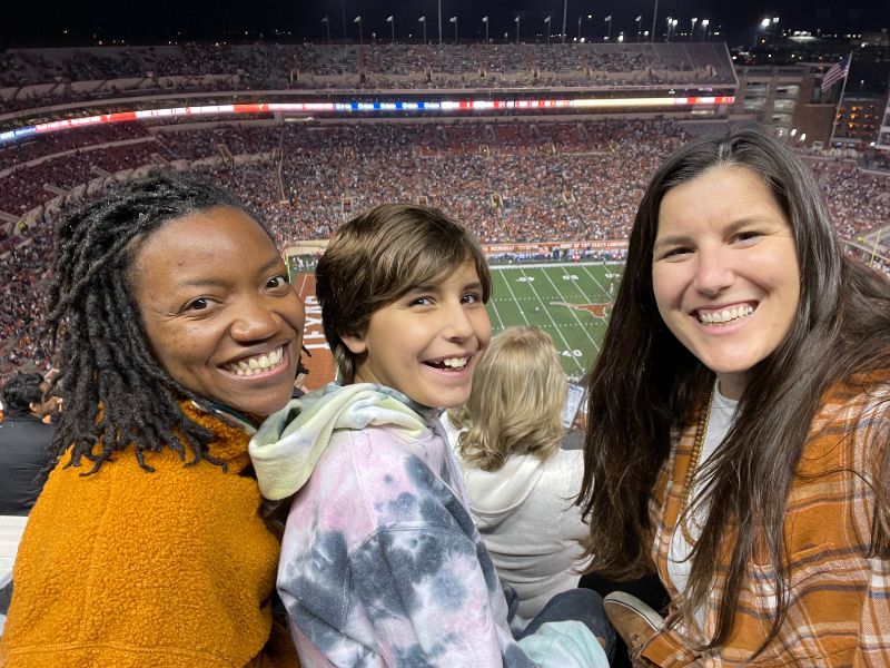 Adoptive moms at a Texas football game with their son