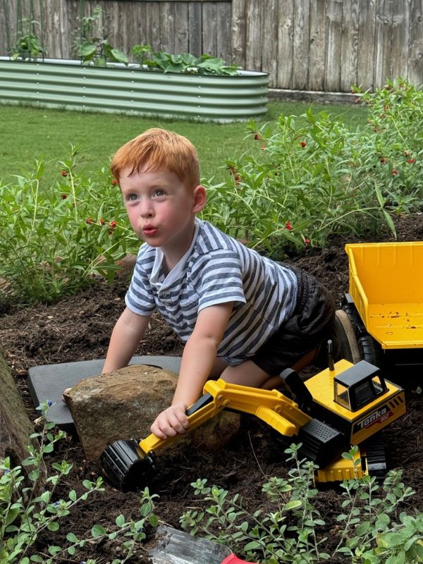 Adopted son playing with trucks in backyard of Houston, TX home