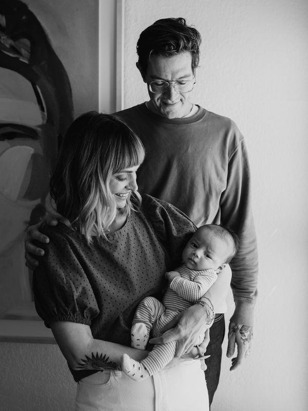 black and white photo of adoptive parents looking at their newborn son with love