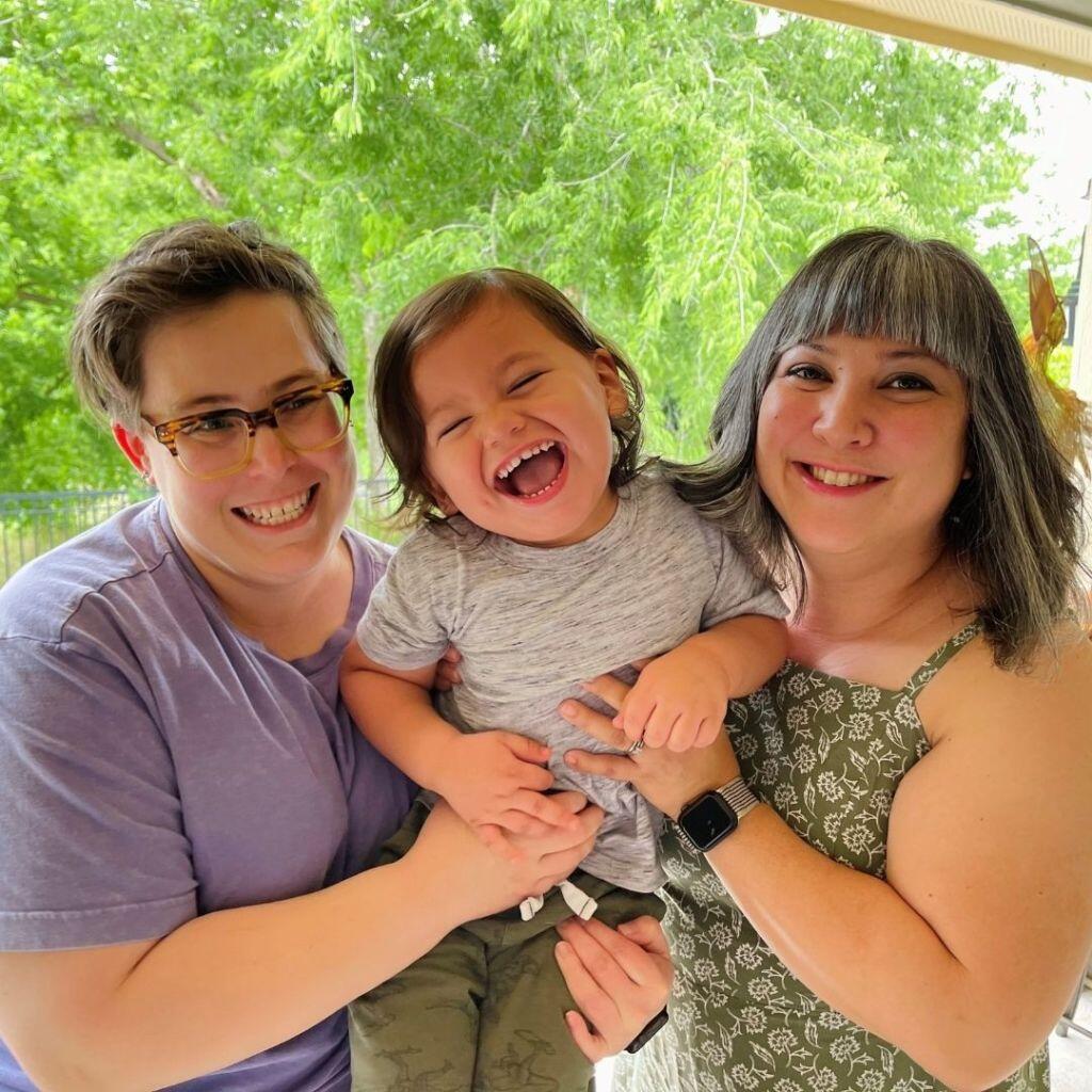 Jenny and Steph, an Austin LGBT couple that wants to adopt a baby, on the porch with their son