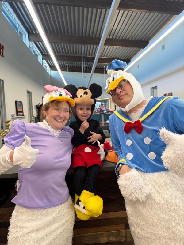 Adoptive family dressed as Mickey Mouse, Donald Duck and Daisy Duck