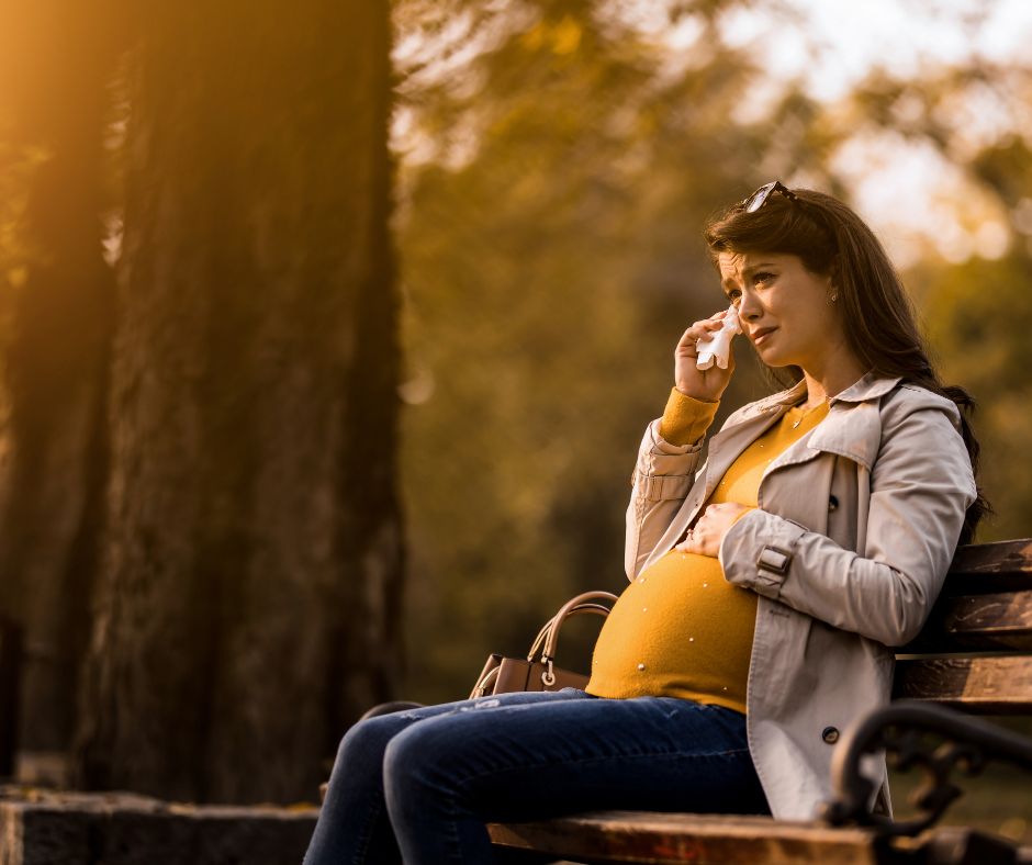 pregnant woman talking on phone to friend about her adoption plan