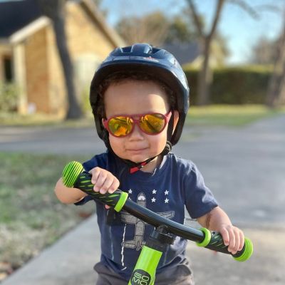 Toddler in helmet and sunglasses on his bicycle